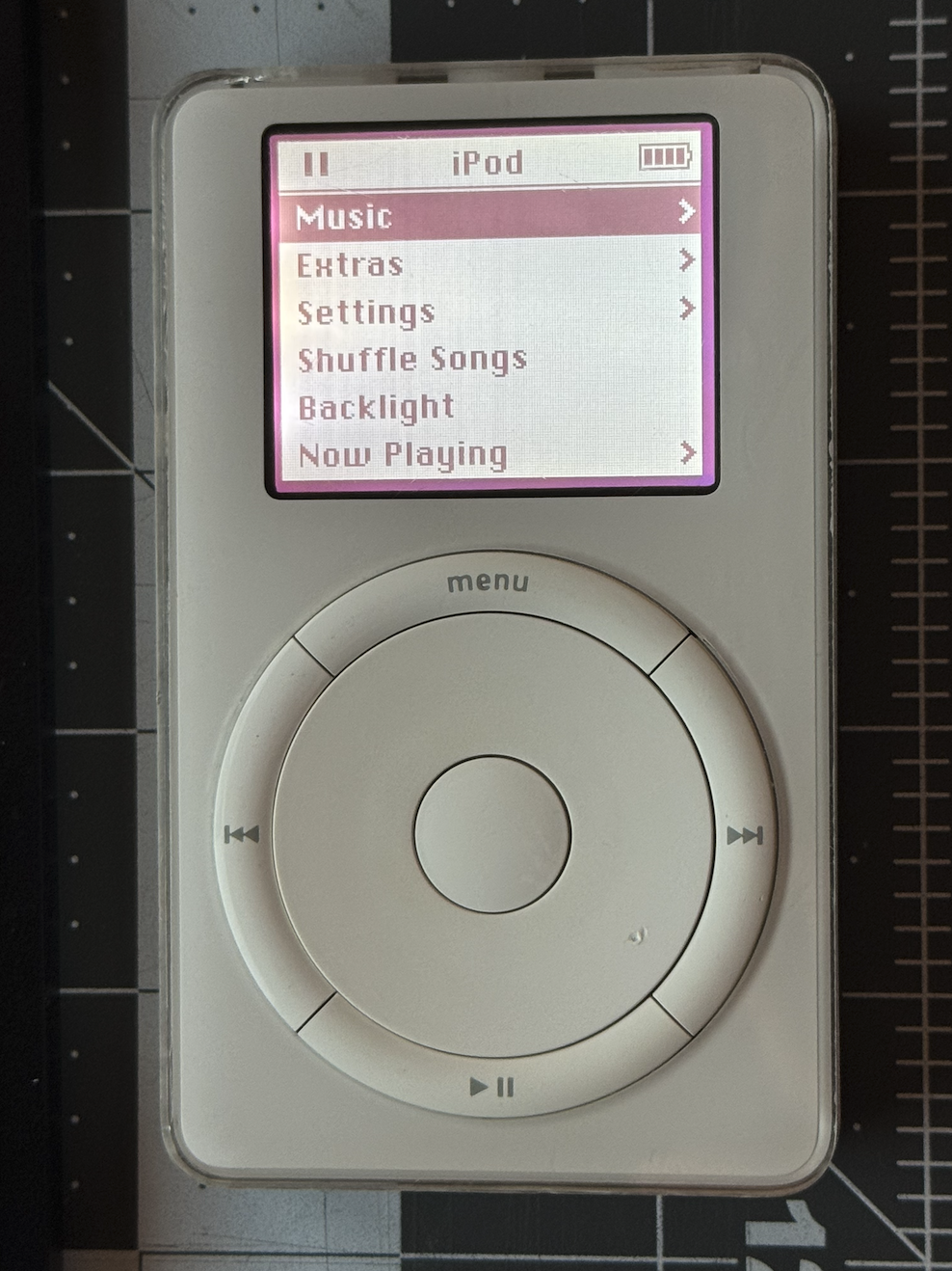 iPod classic 1st gen lying on my desk turned on with the backlight on